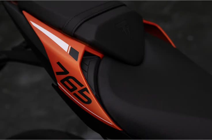 Hardware highlights include fully adjustable Showa suspension Triumph Street Triple R in orange rear seat shot